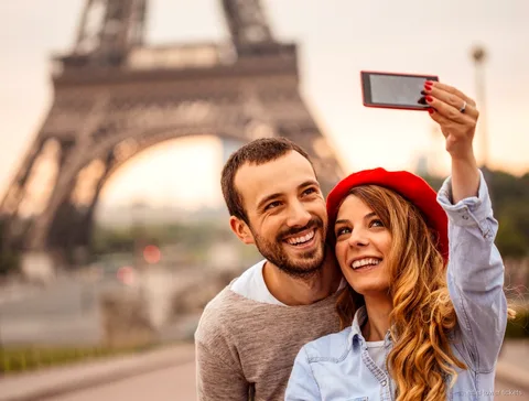 Bilhetes da Torre Eiffel com audioguia: visitante a ouvir junto à torre