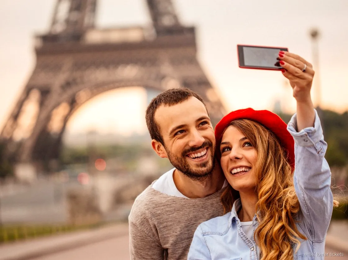 Billet Tour Eiffel avec audioguide : visiteur qui écoute le commentaire près de la tour