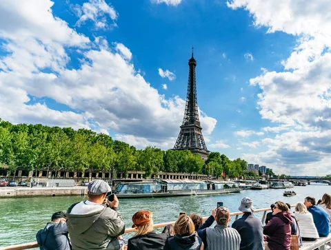 Barco do cruzeiro no rio Sena a passar pela Torre Eiffel