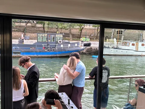 Passengers on the top deck of an Eiffel Tower cruise on the Seine